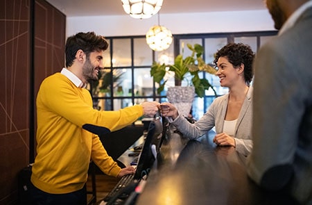 Business Woman Getting Key Card From Hotel Receptionist