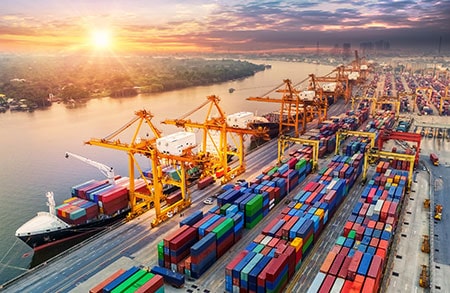 Logistics and Transportation of Container Cargo Ship and Cargo Plane with Working Crane Bridge in Shipyard at Sunrise